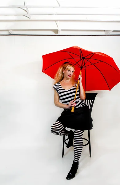 Femme portant audacieux noir et blanc avec parapluie rouge — Photo