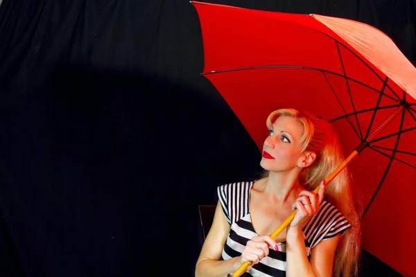 Femme portant audacieux noir et blanc avec parapluie rouge — Photo