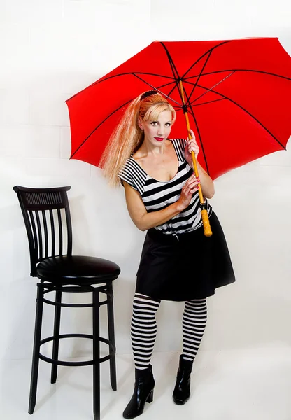 Femme portant audacieux noir et blanc avec parapluie rouge — Photo