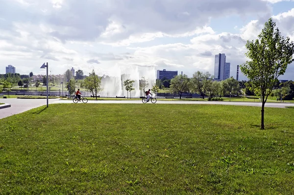 Parkera. På bilden - en man och kvinna går i en park på en cykel — Stockfoto