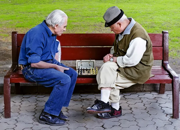 Ältere spielen Schach auf einer Bank — Stockfoto