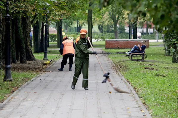 Dozorców zamiatać chodniki w parku — Zdjęcie stockowe