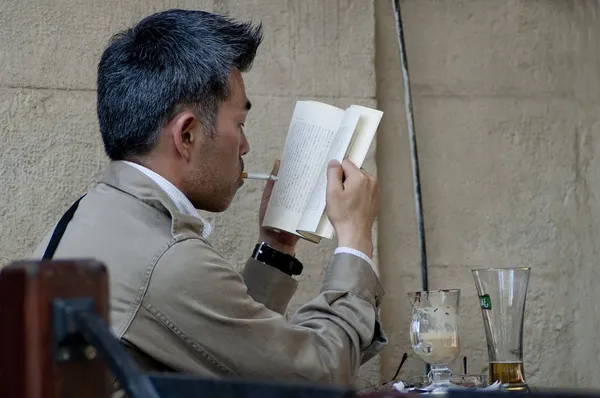 Japanese tourist reads a book in Lvov cafe — Stock Photo, Image