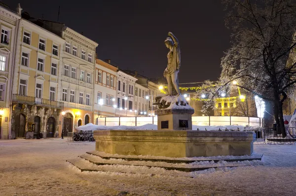 Uma pista de gelo ao ar livre e edifícios antigos no centro da cidade de Lvov — Fotografia de Stock