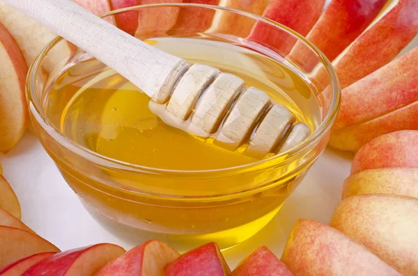 Cortar en rodajas de manzanas con un bol de miel de cerca —  Fotos de Stock