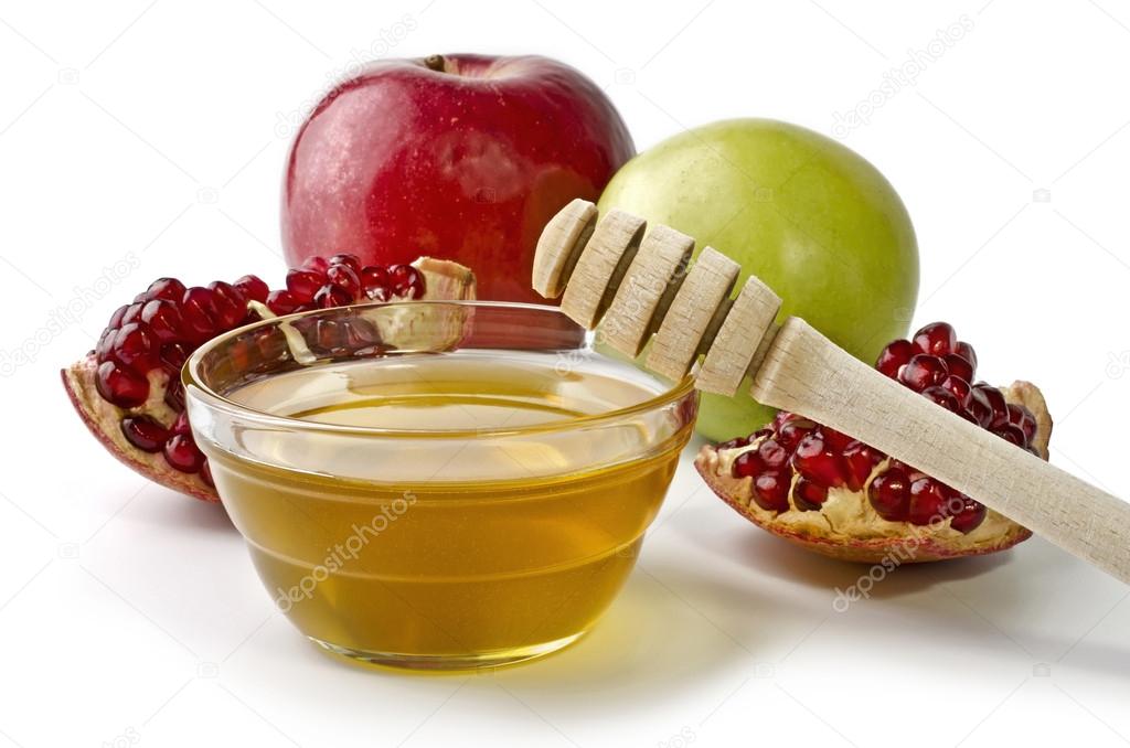 Apples, pomegranate and bowl of honey