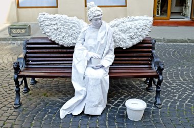 canlı heykel - bir bankta oturan beyaz bir melek