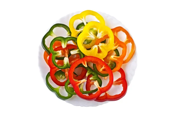 In Scheiben geschnittene süße bunte Paprika auf einem Teller isoliert über weiß — Stockfoto