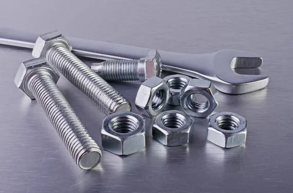 Metal bolts, nuts and wrench — Stock Photo, Image