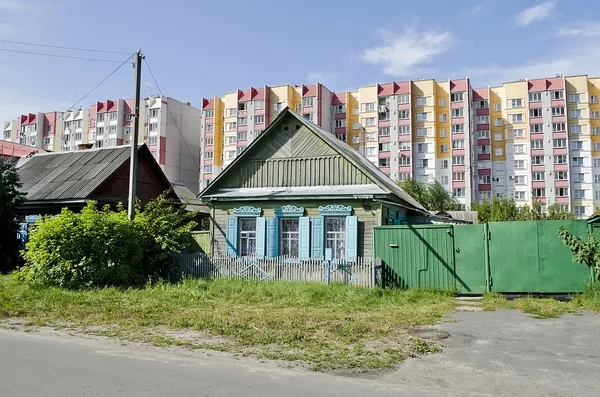 Cottage on the background of high-rise buildings — Stock Photo, Image