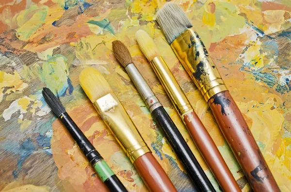 Pincéis de pintura em uma paleta — Fotografia de Stock