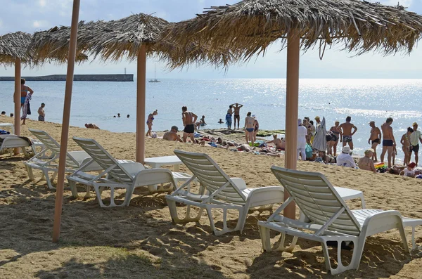 Ligstoelen en strand parasols uit een riet op een strand — Stockfoto