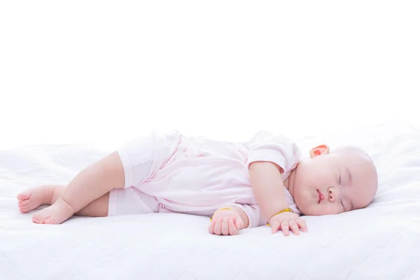 Новорожденная девочка спит в постели — стоковое фото