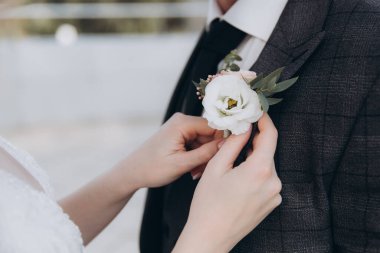 Yeşil yapraklı beyaz gelin buketi ve yaka çiçekli yüzükler