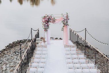 Sonbahar düğünü, iskelede suyun kenarında pembe aylak ayini.