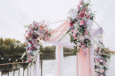 Sonbahar düğünü, iskelede suyun kenarında pembe aylak ayini.