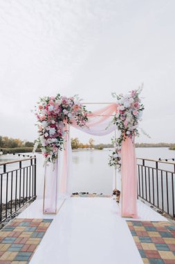 Sonbahar düğünü, iskelede suyun kenarında pembe aylak ayini.