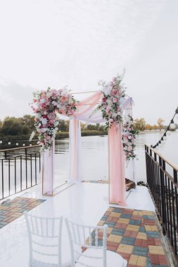 Sonbahar düğünü, iskelede suyun kenarında pembe aylak ayini.