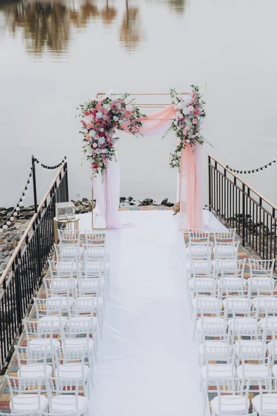 Sonbahar düğünü, iskelede suyun kenarında pembe aylak ayini.