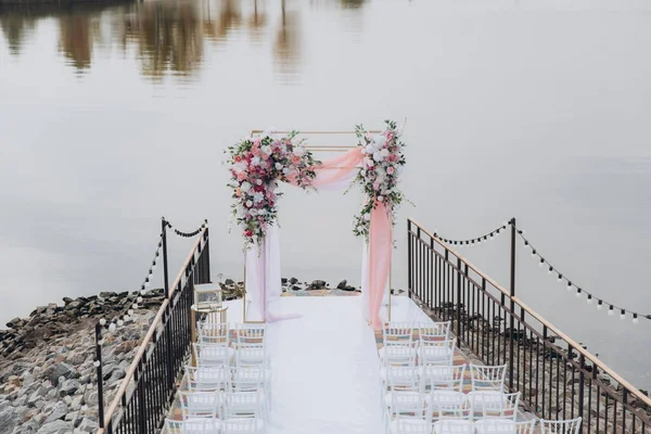 Sonbahar düğünü, iskelede suyun kenarında pembe aylak ayini.