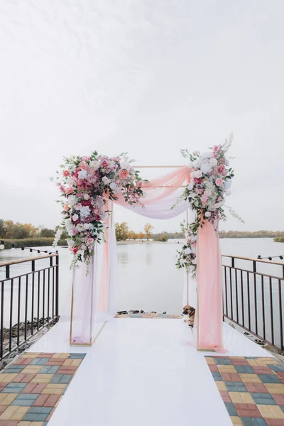 Sonbahar düğünü, iskelede suyun kenarında pembe aylak ayini.