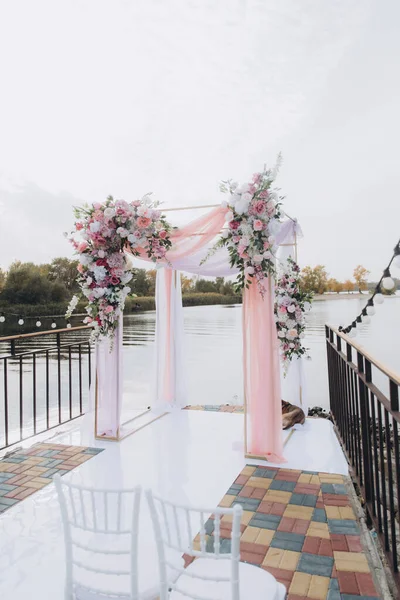 Sonbahar düğünü, iskelede suyun kenarında pembe aylak ayini.