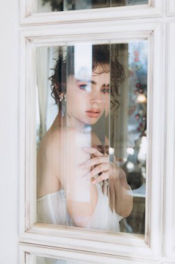 Güzel kıvırcık saçlı gelin lüks bir gelinlik içinde düğün dekorlu bir restoranda