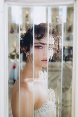 Güzel kıvırcık saçlı gelin lüks bir gelinlik içinde düğün dekorlu bir restoranda