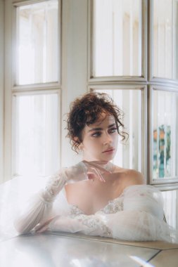 Güzel kıvırcık saçlı gelin lüks bir gelinlik içinde düğün dekorlu bir restoranda