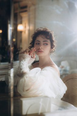 Güzel kıvırcık saçlı gelin lüks bir gelinlik içinde düğün dekorlu bir restoranda