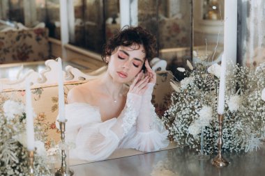 Güzel kıvırcık saçlı gelin lüks bir gelinlik içinde düğün dekorlu bir restoranda