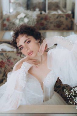 Güzel kıvırcık saçlı gelin lüks bir gelinlik içinde düğün dekorlu bir restoranda