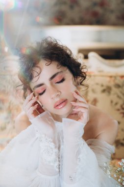 Güzel kıvırcık saçlı gelin lüks bir gelinlik içinde düğün dekorlu bir restoranda