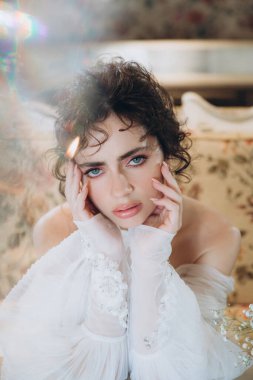 Güzel kıvırcık saçlı gelin lüks bir gelinlik içinde düğün dekorlu bir restoranda