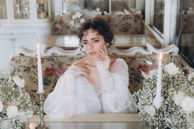 Güzel kıvırcık saçlı gelin lüks bir gelinlik içinde düğün dekorlu bir restoranda