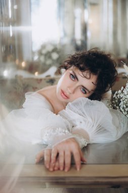 Güzel kıvırcık saçlı gelin lüks bir gelinlik içinde düğün dekorlu bir restoranda