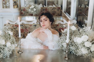 Güzel kıvırcık saçlı gelin lüks bir gelinlik içinde düğün dekorlu bir restoranda