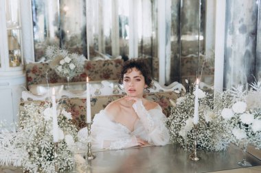 Güzel kıvırcık saçlı gelin lüks bir gelinlik içinde düğün dekorlu bir restoranda