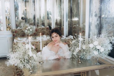 Güzel kıvırcık saçlı gelin lüks bir gelinlik içinde düğün dekorlu bir restoranda