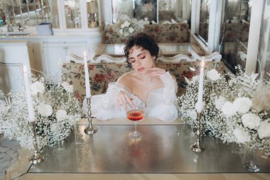 Güzel kıvırcık saçlı gelin lüks bir gelinlik içinde düğün dekorlu bir restoranda