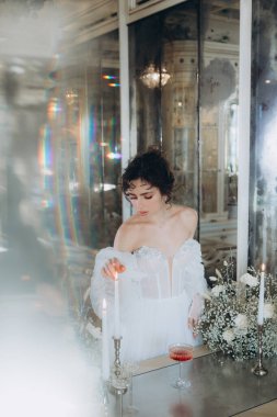 Güzel kıvırcık saçlı gelin lüks bir gelinlik içinde düğün dekorlu bir restoranda