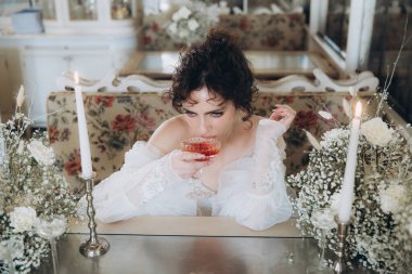 Güzel kıvırcık saçlı gelin lüks bir gelinlik içinde düğün dekorlu bir restoranda