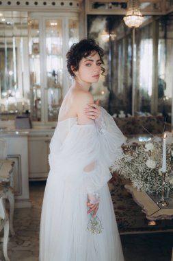 Güzel kıvırcık saçlı gelin lüks bir gelinlik içinde düğün dekorlu bir restoranda