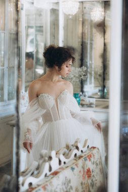 Güzel kıvırcık saçlı gelin lüks bir gelinlik içinde düğün dekorlu bir restoranda