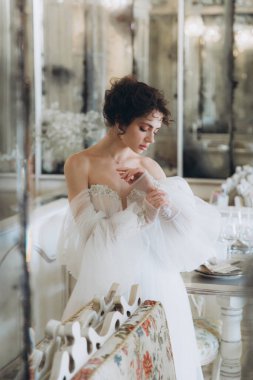Güzel kıvırcık saçlı gelin lüks bir gelinlik içinde düğün dekorlu bir restoranda
