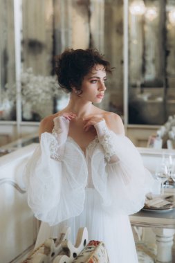 Güzel kıvırcık saçlı gelin lüks bir gelinlik içinde düğün dekorlu bir restoranda