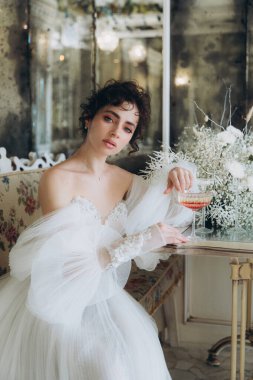 Güzel kıvırcık saçlı gelin lüks bir gelinlik içinde düğün dekorlu bir restoranda