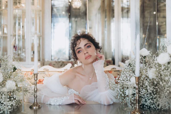 Güzel kıvırcık saçlı gelin lüks bir gelinlik içinde düğün dekorlu bir restoranda