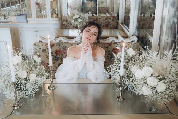Güzel kıvırcık saçlı gelin lüks bir gelinlik içinde düğün dekorlu bir restoranda