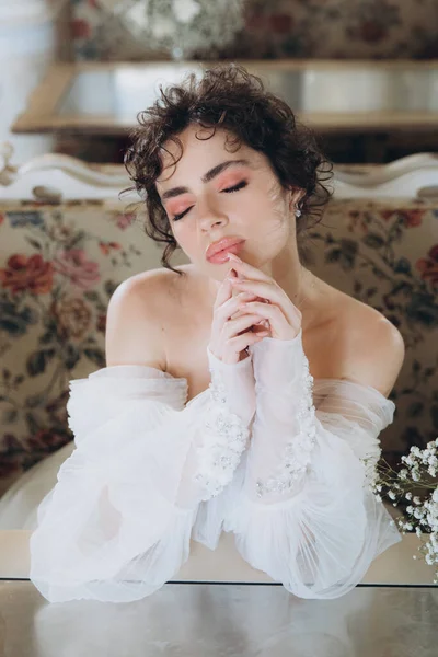 Güzel kıvırcık saçlı gelin lüks bir gelinlik içinde düğün dekorlu bir restoranda
